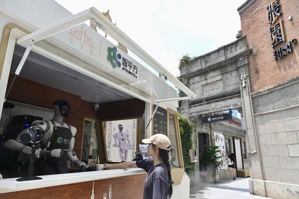 2026年7月19日，上海张园，一位顾客正从机器人那里接过咖啡。澎湃新闻记者 吴栋 图