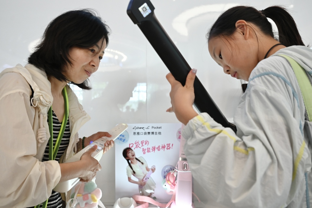 2026年7月19日，上海张江AI应用商店，一对母女正在一起琢磨AI辅助弹唱。澎湃新闻记者 吴栋 图